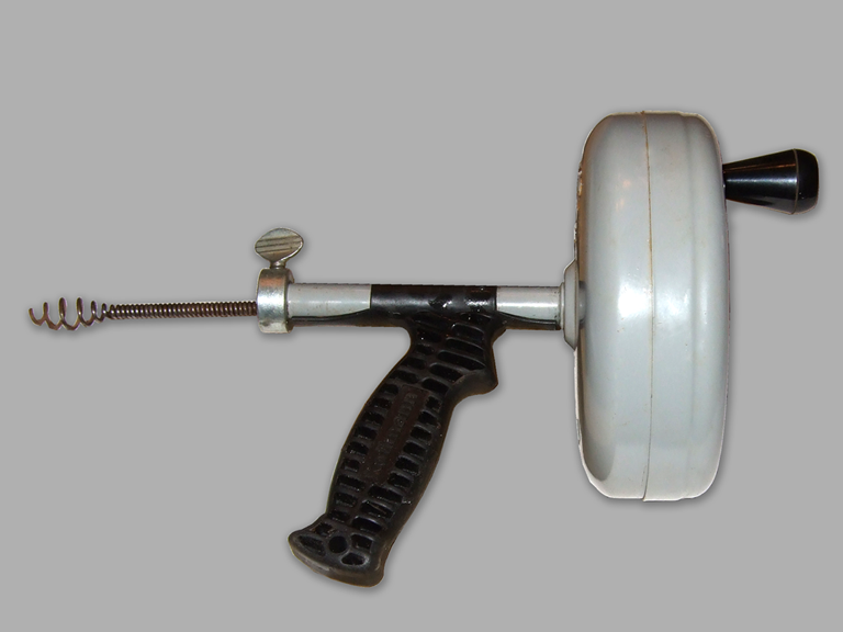 Handheld drain snake with white canister cable spool